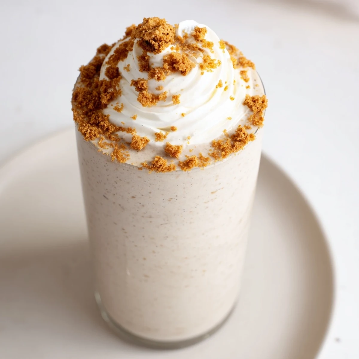 Creamy gingerbread smoothie, blended with spices, topped with whipped cream, ready to enjoy.