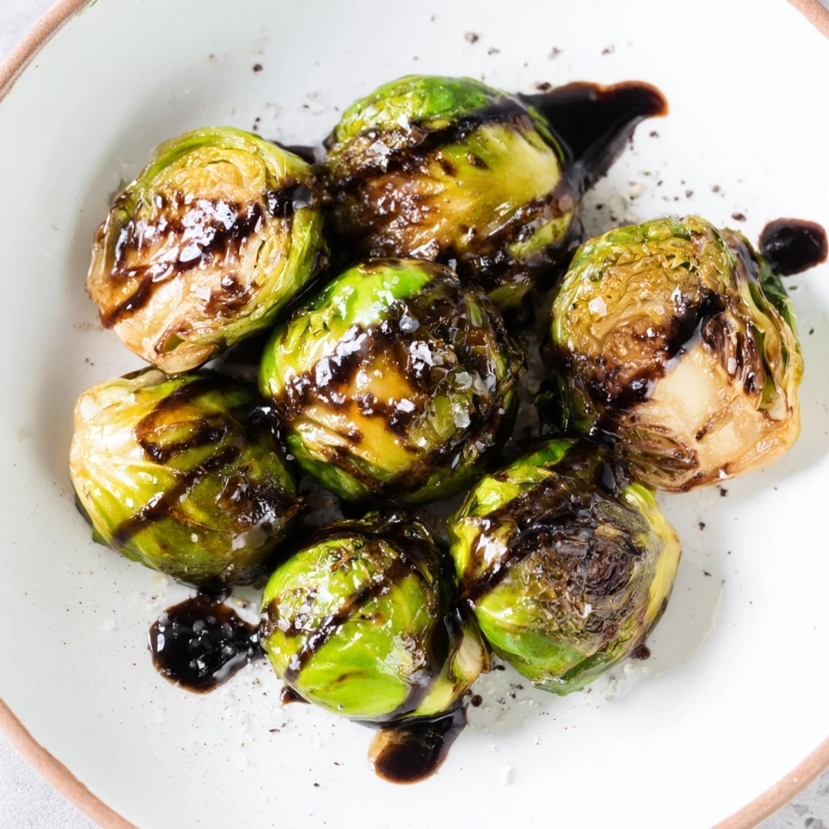 Crispy roasted Brussels sprouts, their edges caramelized beautifully with sweet balsamic glaze drizzle.