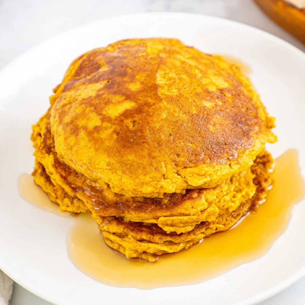 Delicious Spiced Pumpkin Pancakes, served with syrup, waiting to be enjoyed during brunch.
