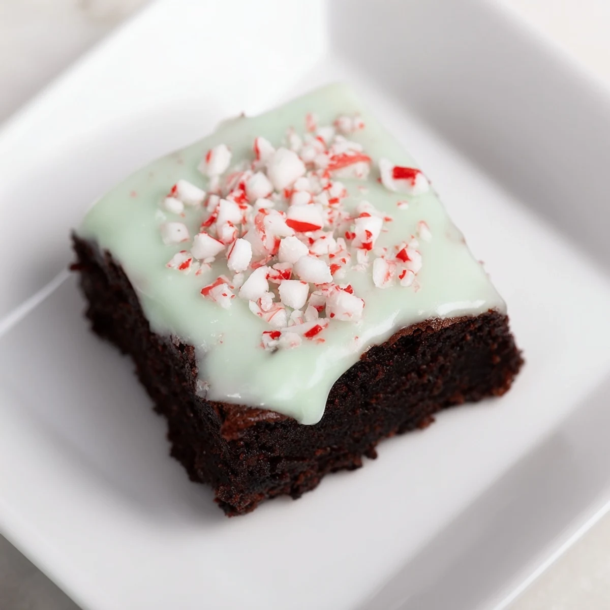 Warm, fudgy Peppermint Brownies, glazed with a cool mint frosting and crushed candy canes.