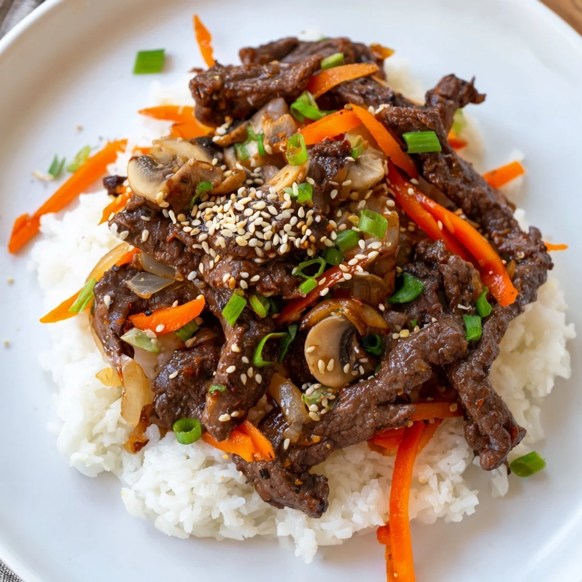A steaming bowl of Korean Beef with vibrant vegetables, perfect over fluffy white rice for dinner.