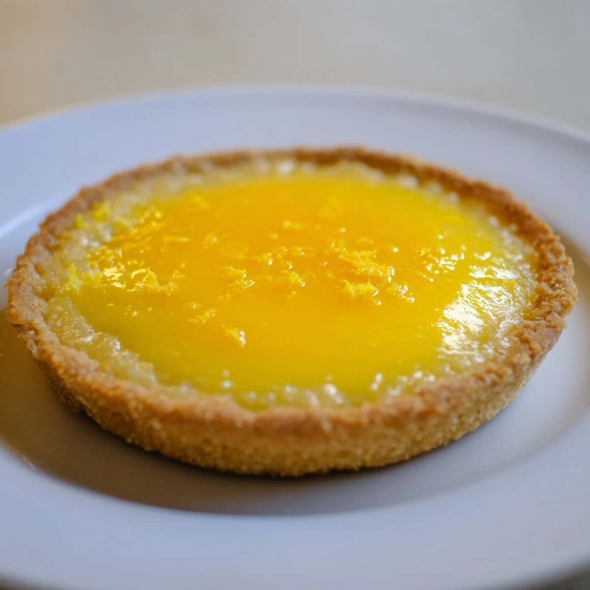 A beautiful slice of tart lemon, showing the smooth, yellow filling and golden crust.