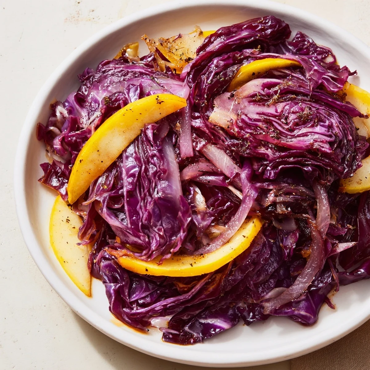 A close-up of savory Braised Red Cabbage, showcasing soft, glistening cabbage and juicy apples.
