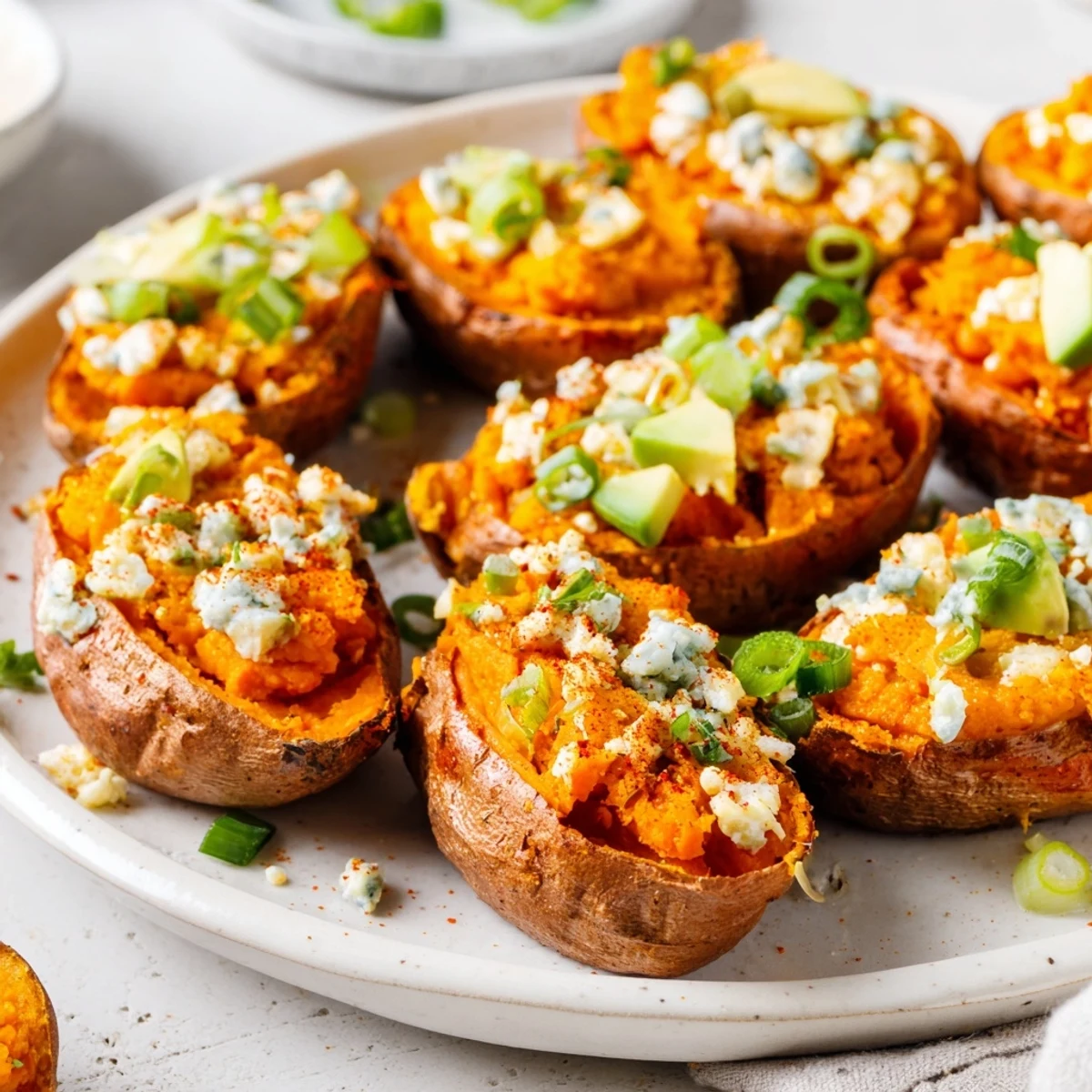 A close-up of delicious Loaded Sweet Potato Skins sizzling with black bean filling and a cheese topping.