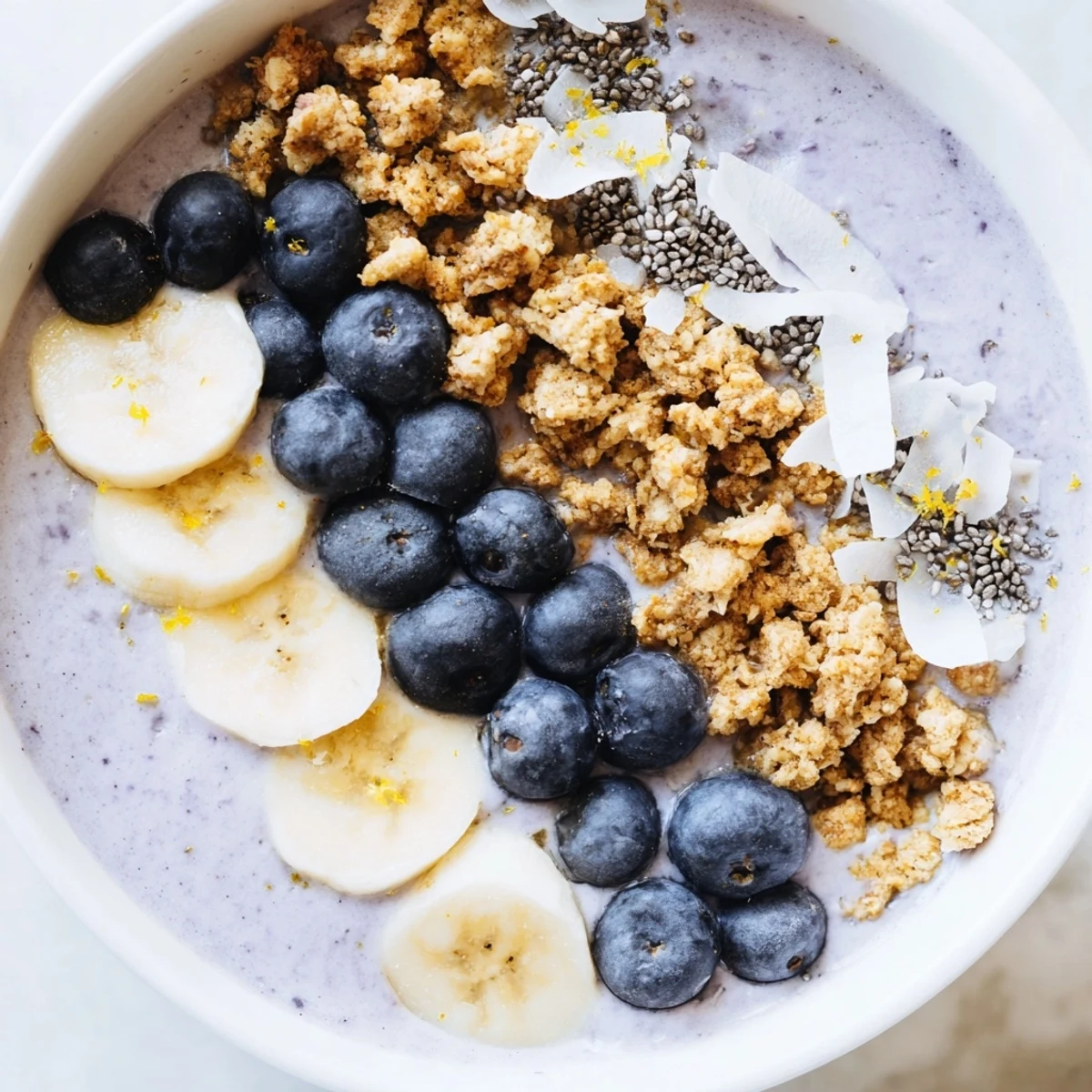 Vibrant lemon blueberry smoothie bowl topped with fresh berries and granola, ready to enjoy.