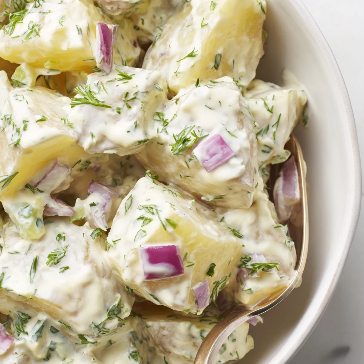 Creamy Potato Salad with Fresh Dill served chilled at a backyard barbecue.