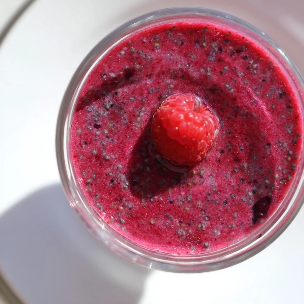 Thick and frosty Valentine Red Berry Smoothie blended with ice, poured into a tall glass ready for a healthy snack.