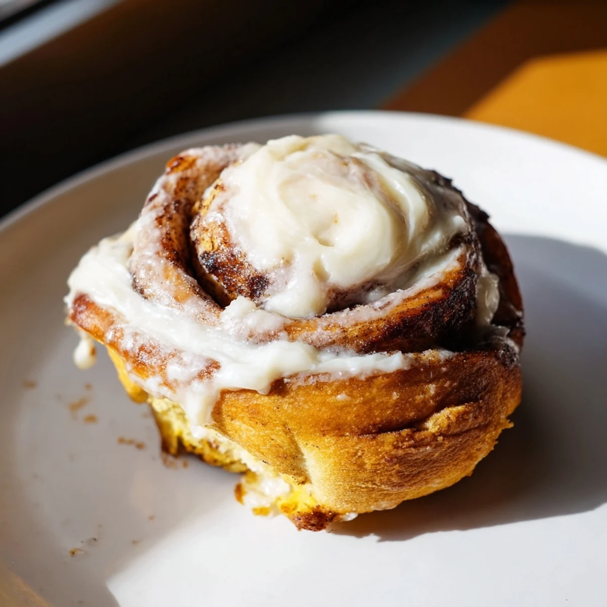Keto Cinnamon Buns glazed and stacked on a white plate, drizzled with creamy icing and a sprinkle of cinnamon for a cozy breakfast treat.