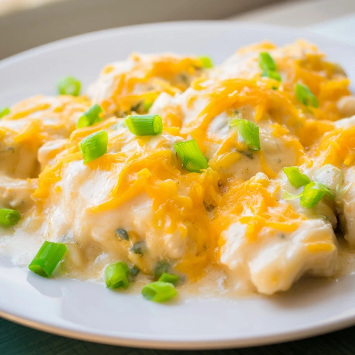 Golden-brown baked chicken breasts smothered in creamy sour cream and onion sauce, topped with melted cheddar cheese for a cozy weeknight meal.