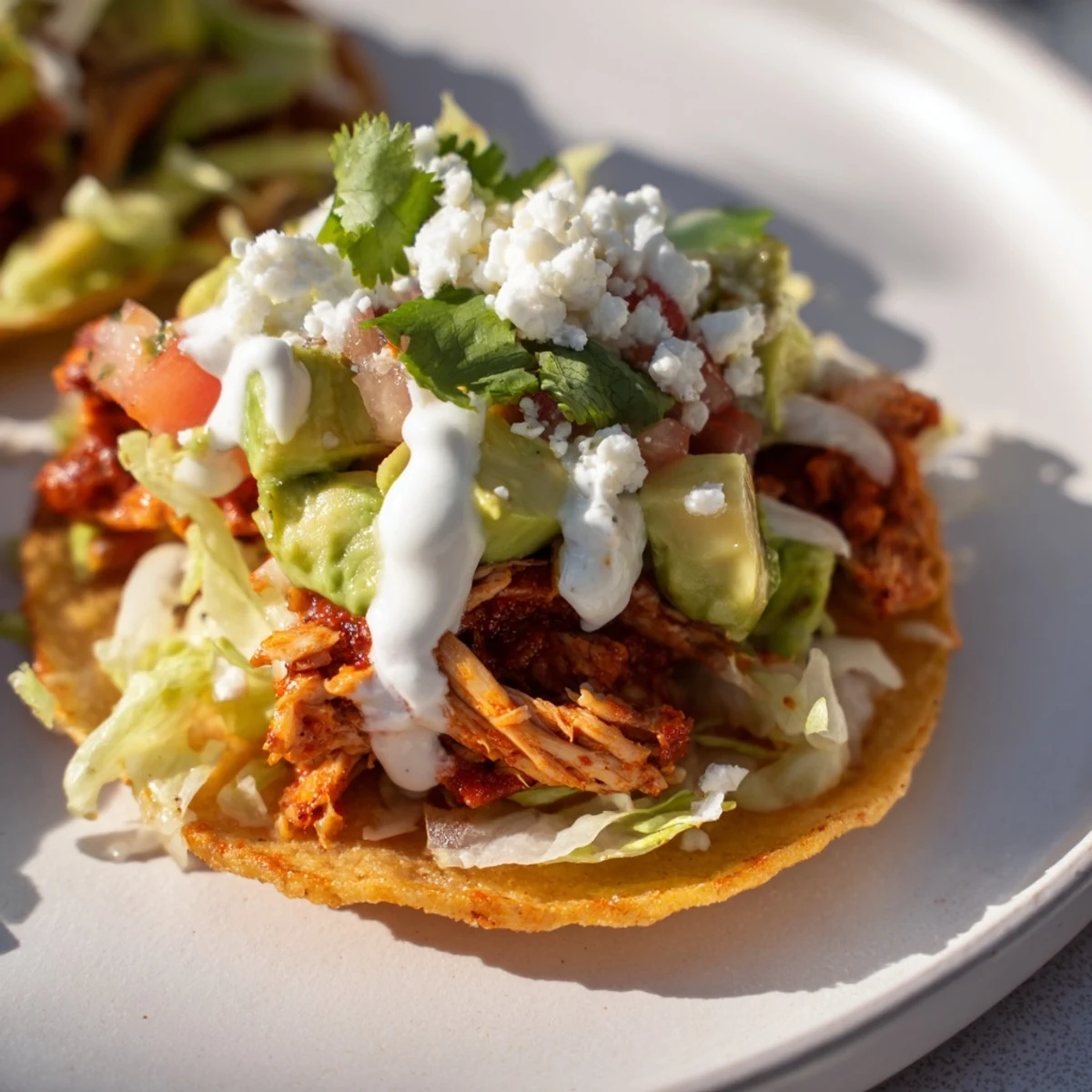 Delicious bite-sized gluten-free mini chicken tostadas garnished with cilantro and served with lime wedges for dipping.