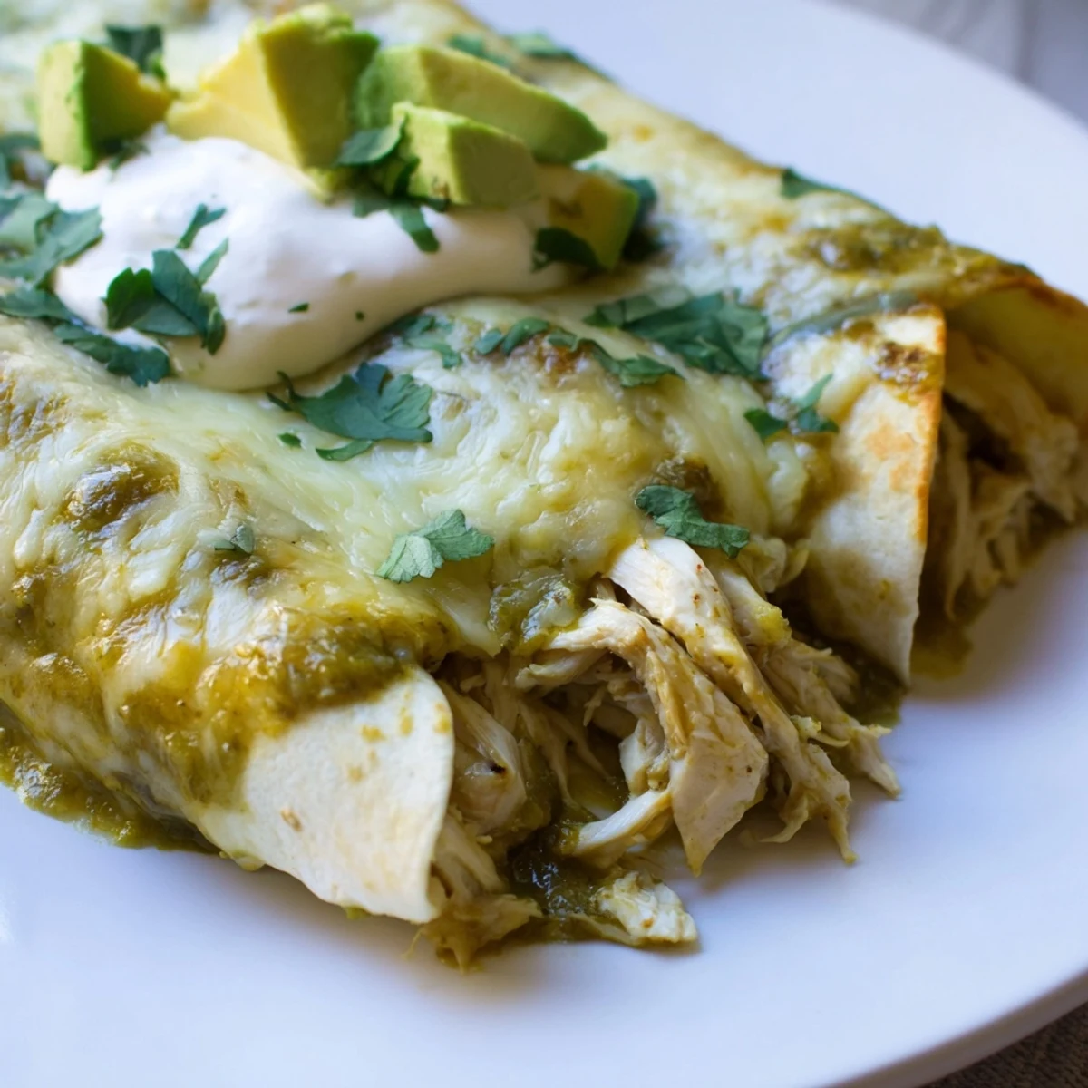 Perfectly baked Green Enchiladas With Chicken bubbling with melted Monterey Jack cheese.