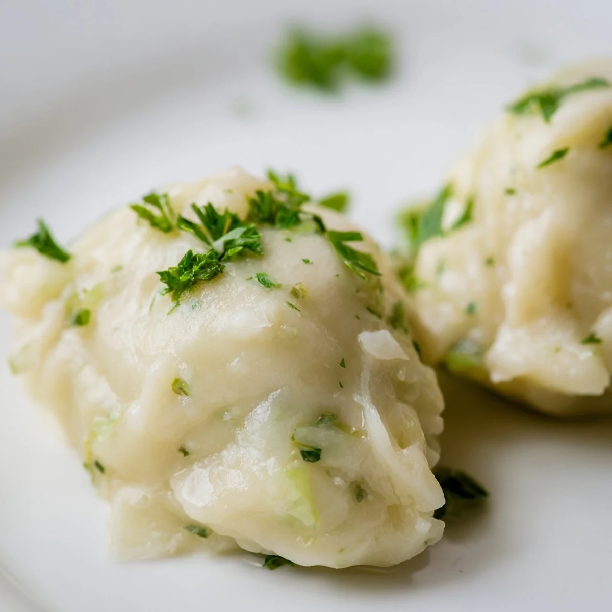 Tender German Cabbage Dumplings simmering in savory broth, garnished with fresh parsley for a comforting vegetarian meal.