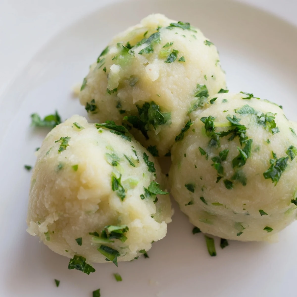 Steamed German Cabbage Dumplings on a plate, ready to be paired with a creamy mushroom sauce.