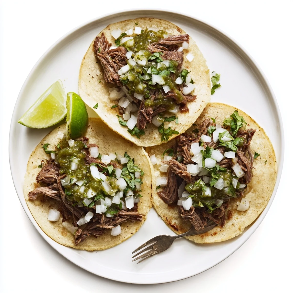 Tender slow-braised beef cheek tacos served in warm corn tortillas topped with fresh cilantro and diced onion.