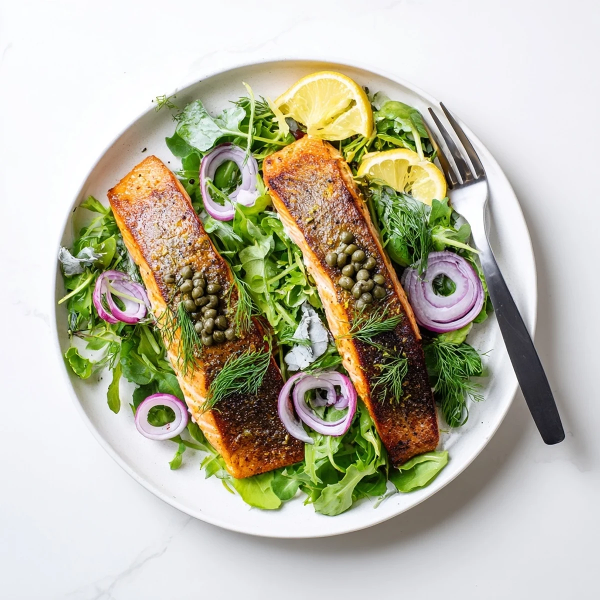 Perfectly seared Crispy Skin Tasmanian Atlantic Salmon fillets resting beside a vibrant lemony herb salad.