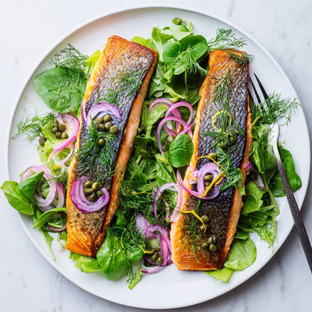 Golden-brown Crispy Skin Tasmanian Atlantic Salmon glistening with olive oil atop a bed of fresh greens.