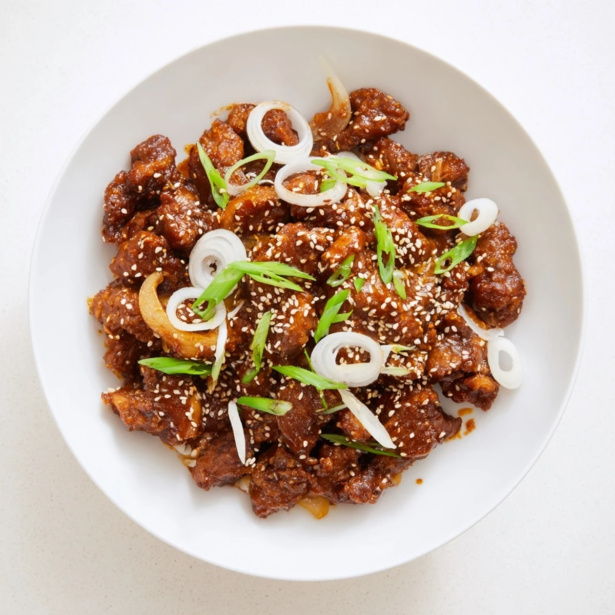 Tender Slow Cooker Korean Beef shredded in glossy brown sauce with green onion garnish