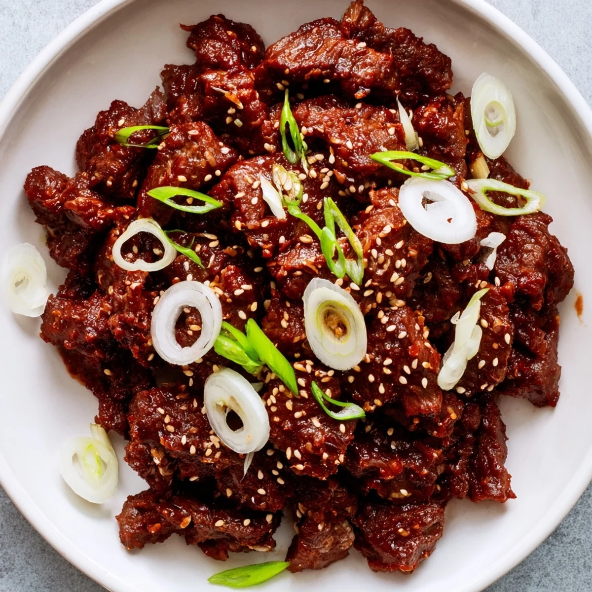 Savory slow cooker Korean beef served over steamed white rice with sesame seed topping