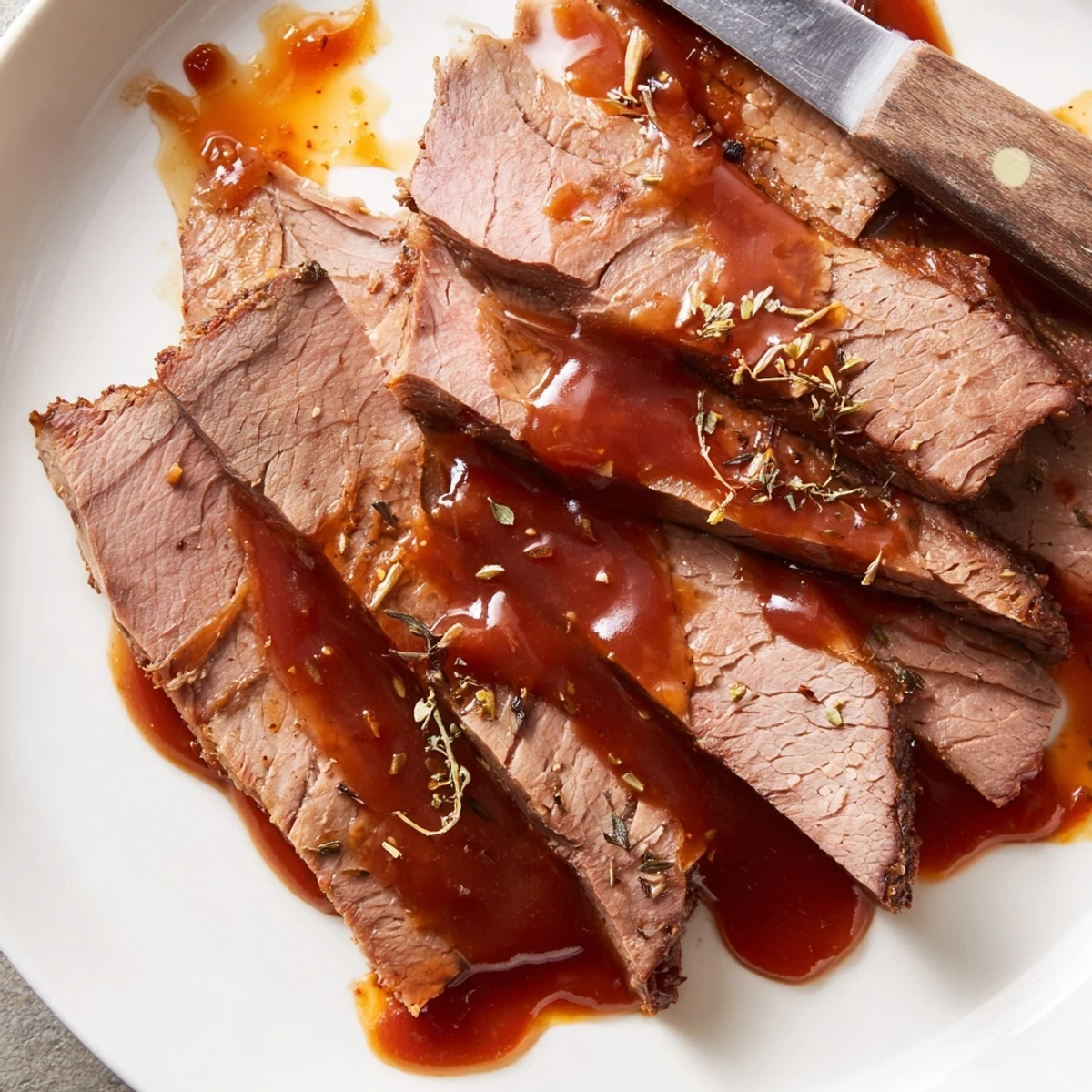 Tender slow cooker beef brisket with caramelized onions and rich savory sauce drizzled over sliced meat