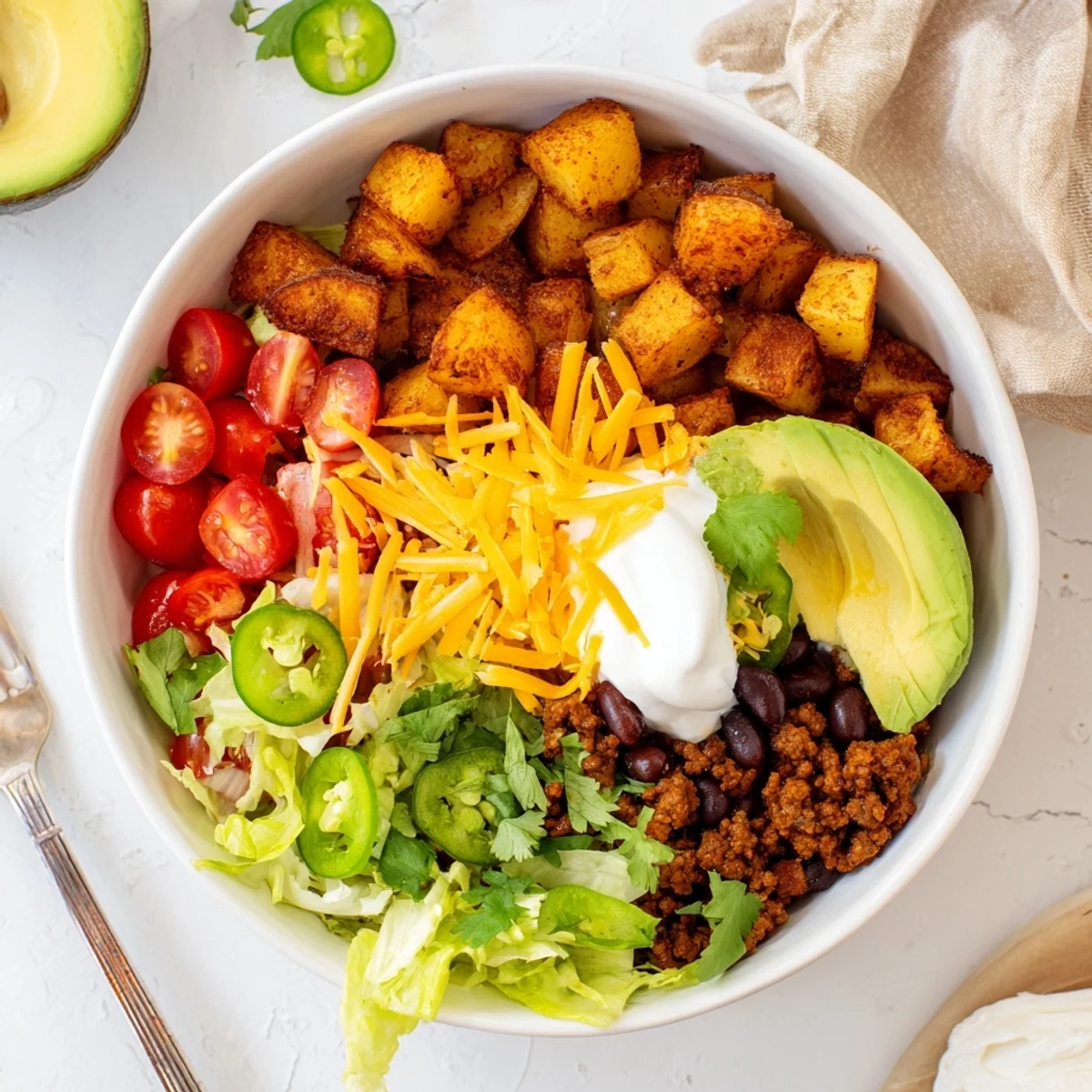 Tex-Mex loaded potato taco bowl mounded with beans avocado lettuce and zesty salsa