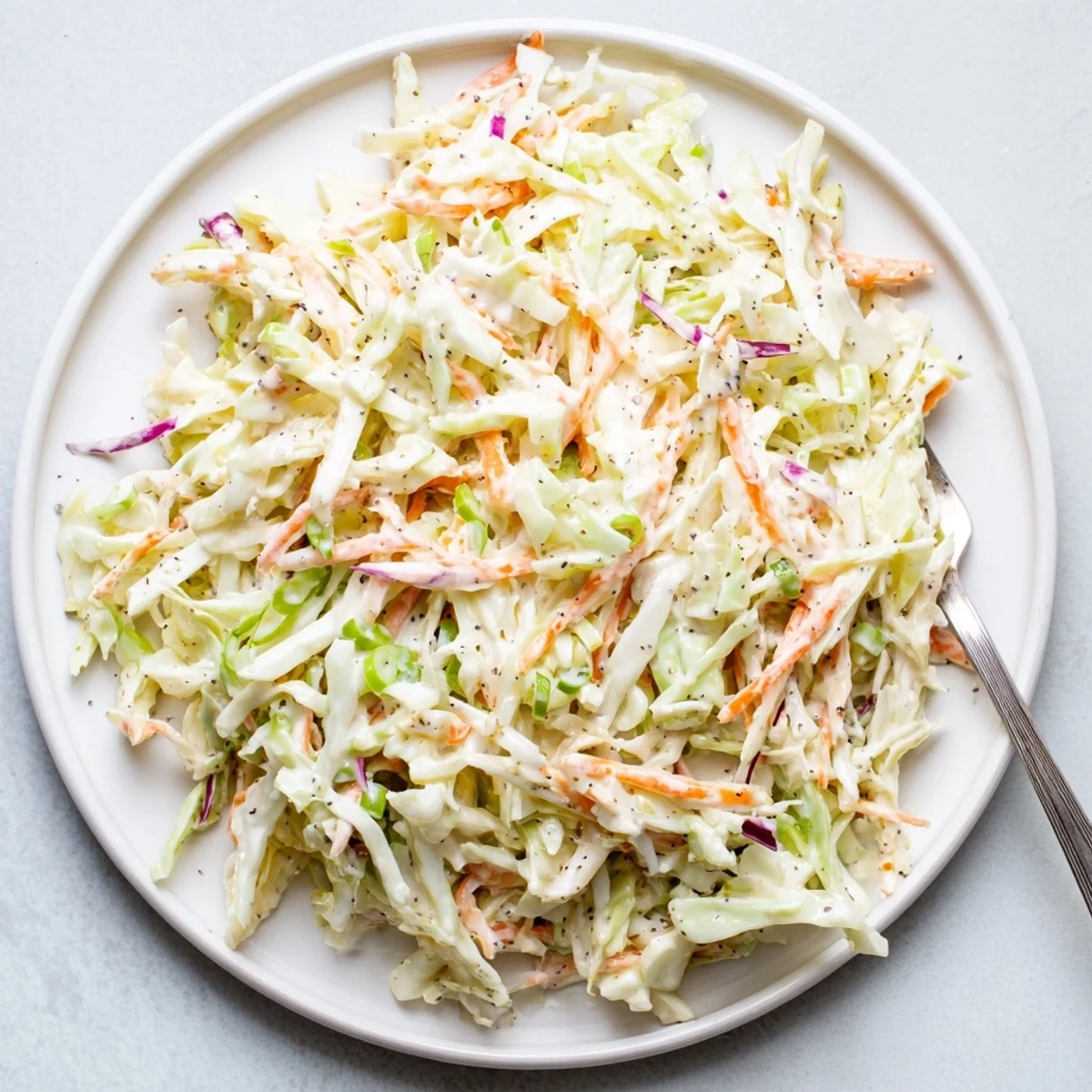 Crisp shredded green and red cabbage coated in tangy creamy easy creamy coleslaw dressing