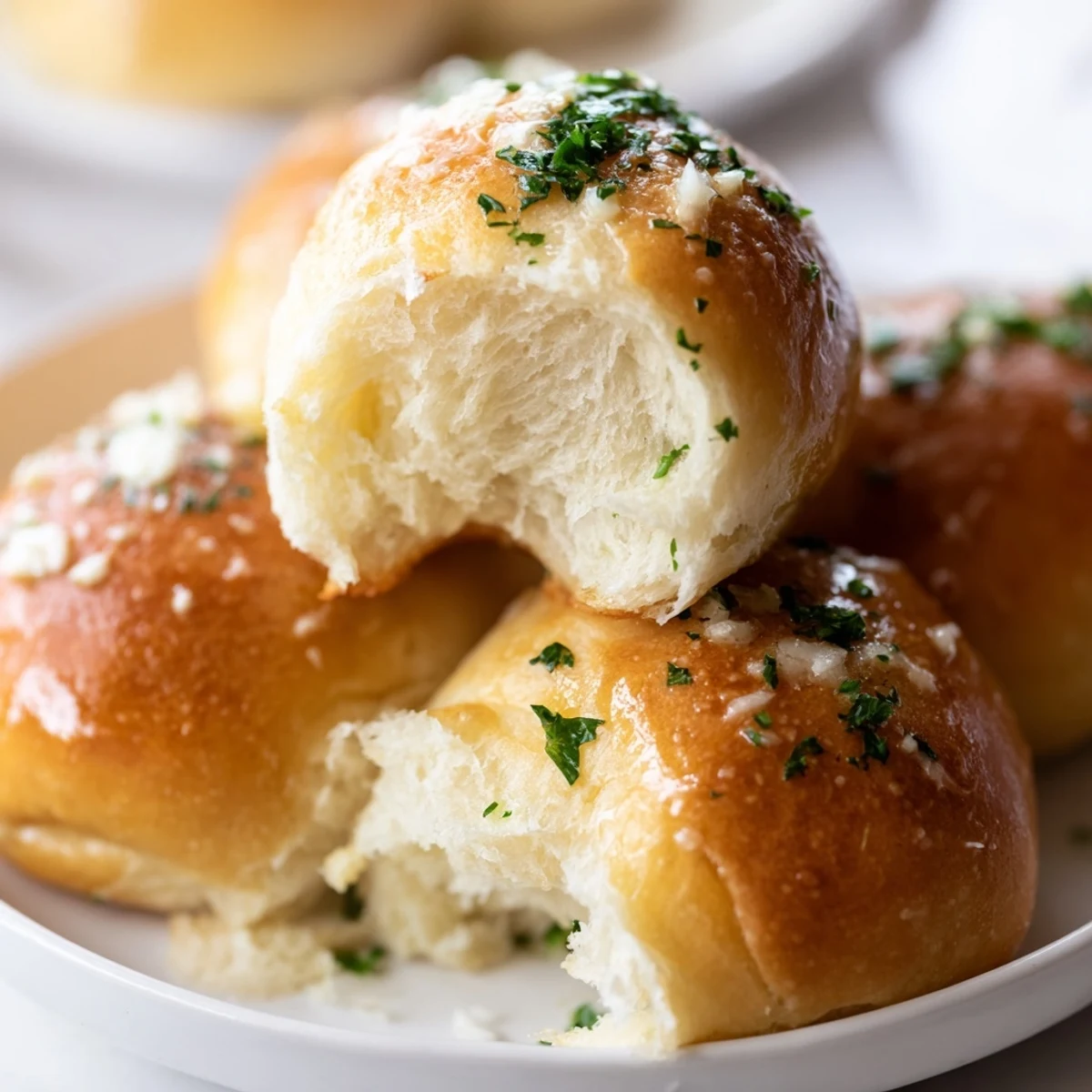 Golden homemade garlic bread rolls fresh from the oven with parsley and Parmesan topping