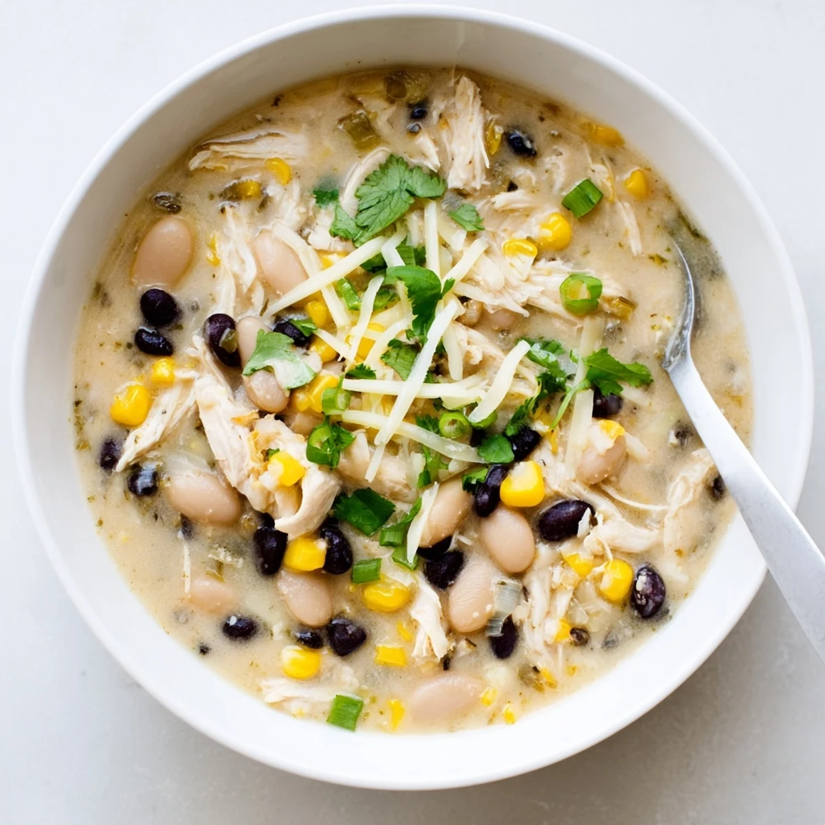 Hearty thick white chicken chili with black beans in a rustic serving pot
