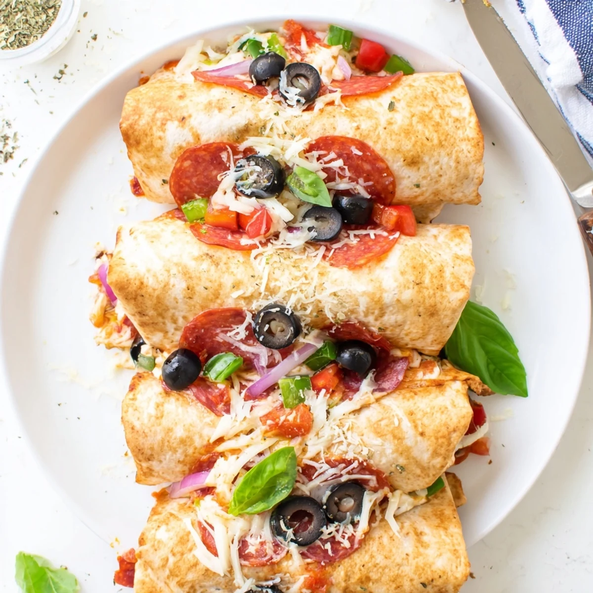 Golden oven baked pizza burritos stuffed with melted mozzarella and pepperoni on parchment paper