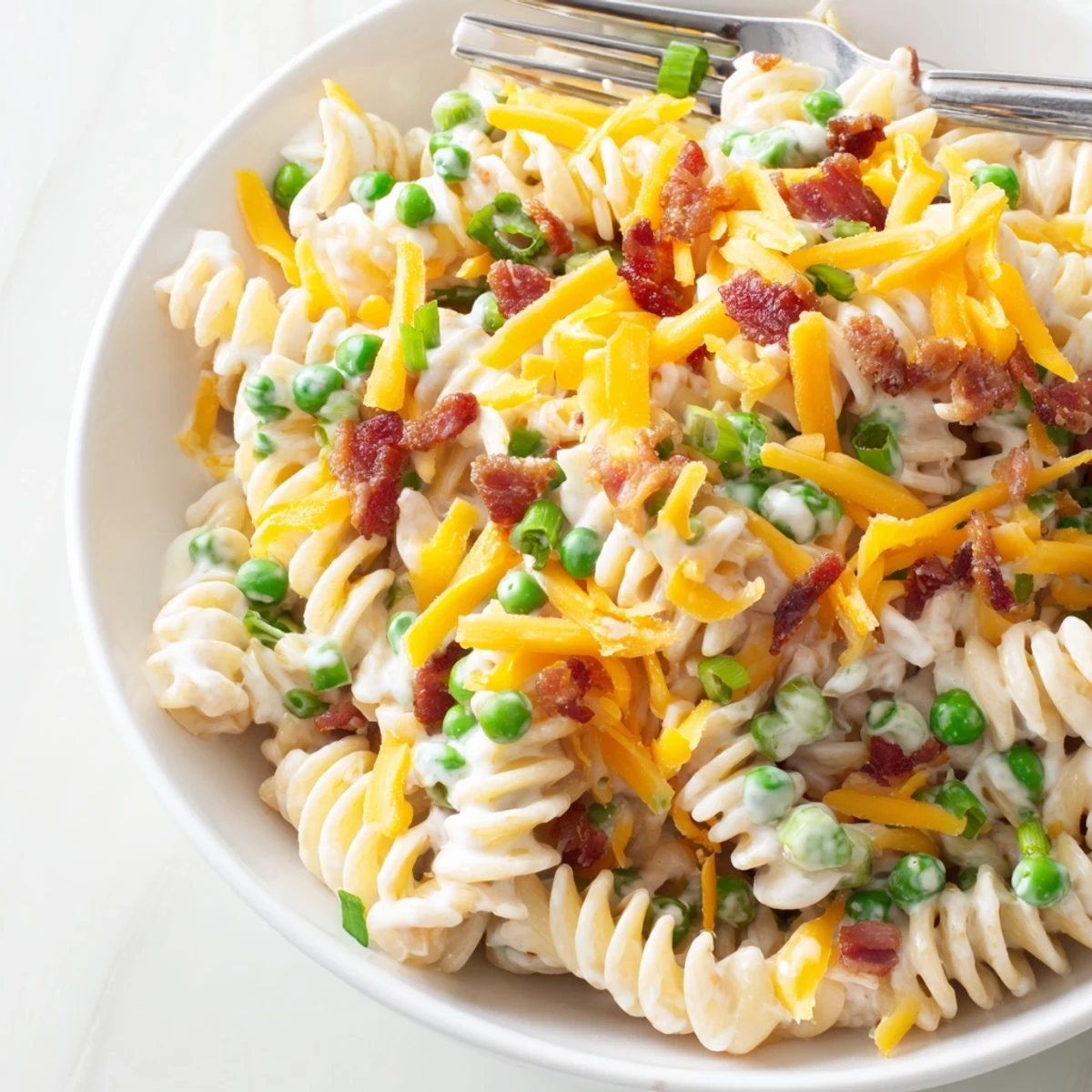 Addictive crack pasta salad with rotini noodles, peas, and crumbled bacon coated in tangy ranch dressing