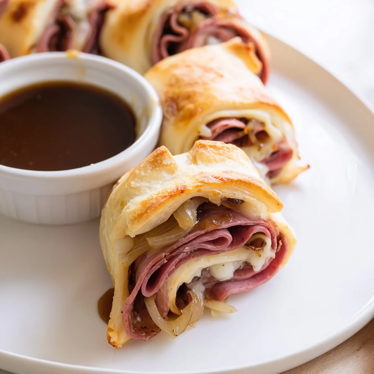 Crispy baked beef and cheese French dip roll ups oozing with melted provolone