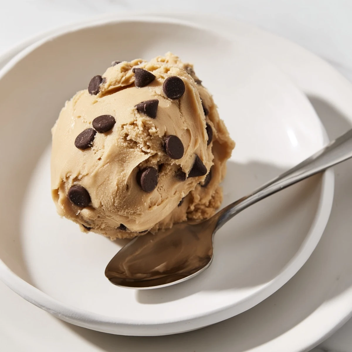 Creamy chocolate chip cookie dough scooped into balls and studded with chocolate chips