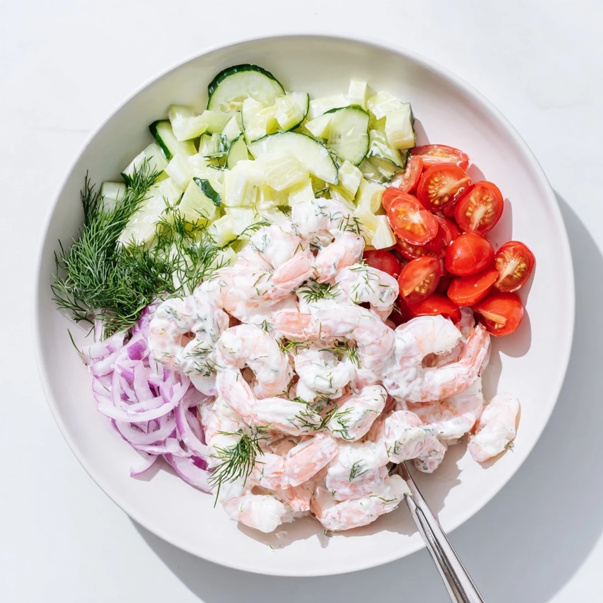 Creamy shrimp salad recipe in a bowl with diced cucumber and red onion