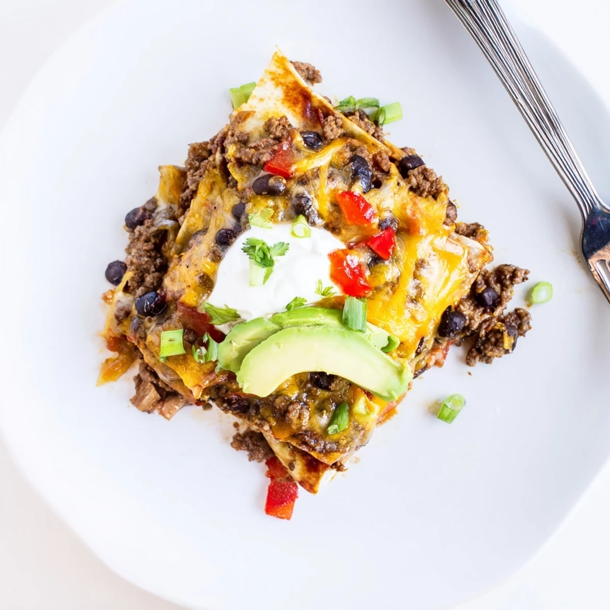 Beef Skillet Enchiladas bubbling in skillet with melted cheese and cilantro garnish