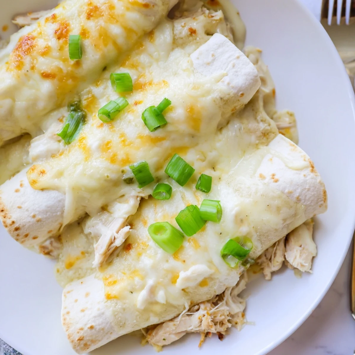 Sliced and plated, Creamy White Chicken Enchiladas with Spanish rice and salad.