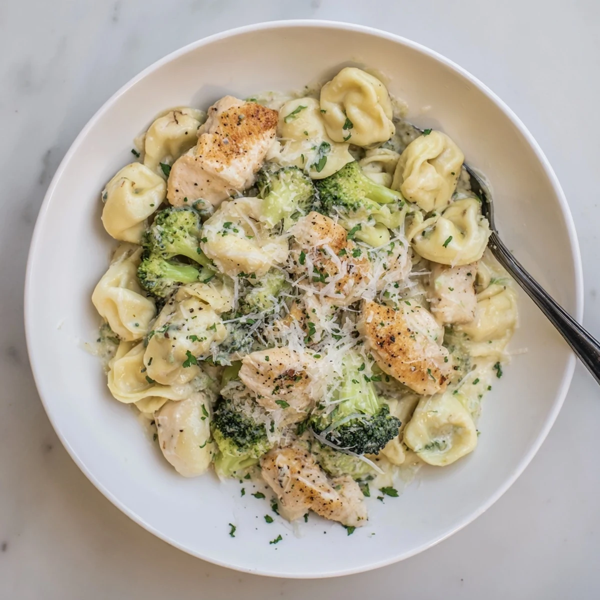 Creamy Garlic Parmesan Tortellini Chicken Broccoli Recipe steaming in skillet, cheese melting  