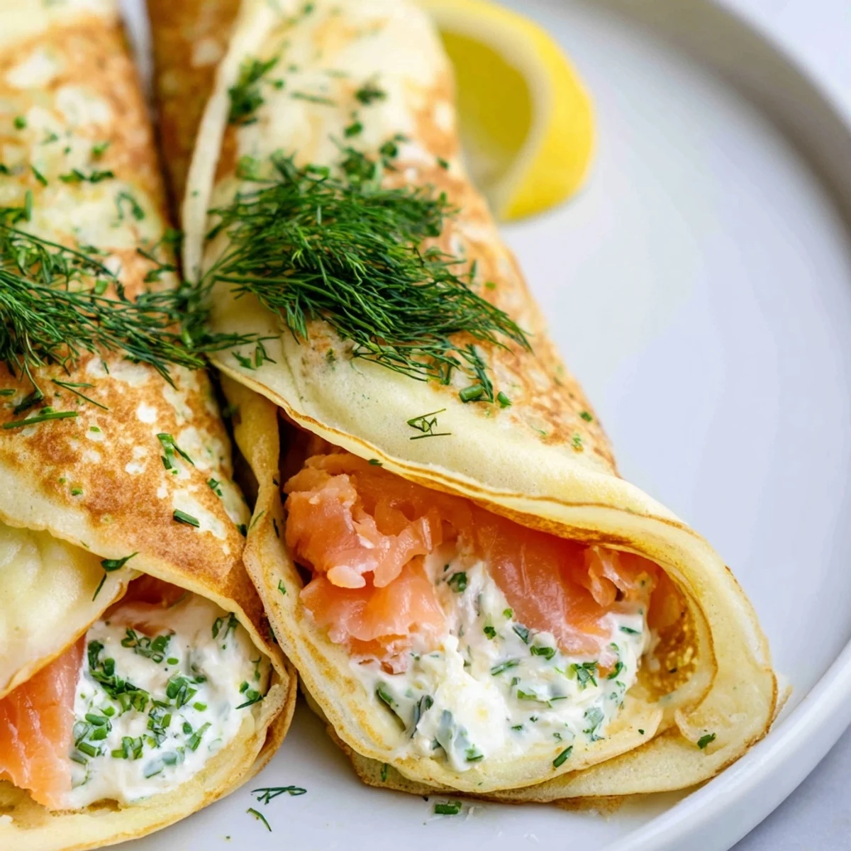 Golden rolled crepes filled with pink smoked salmon slices and creamy herb spread