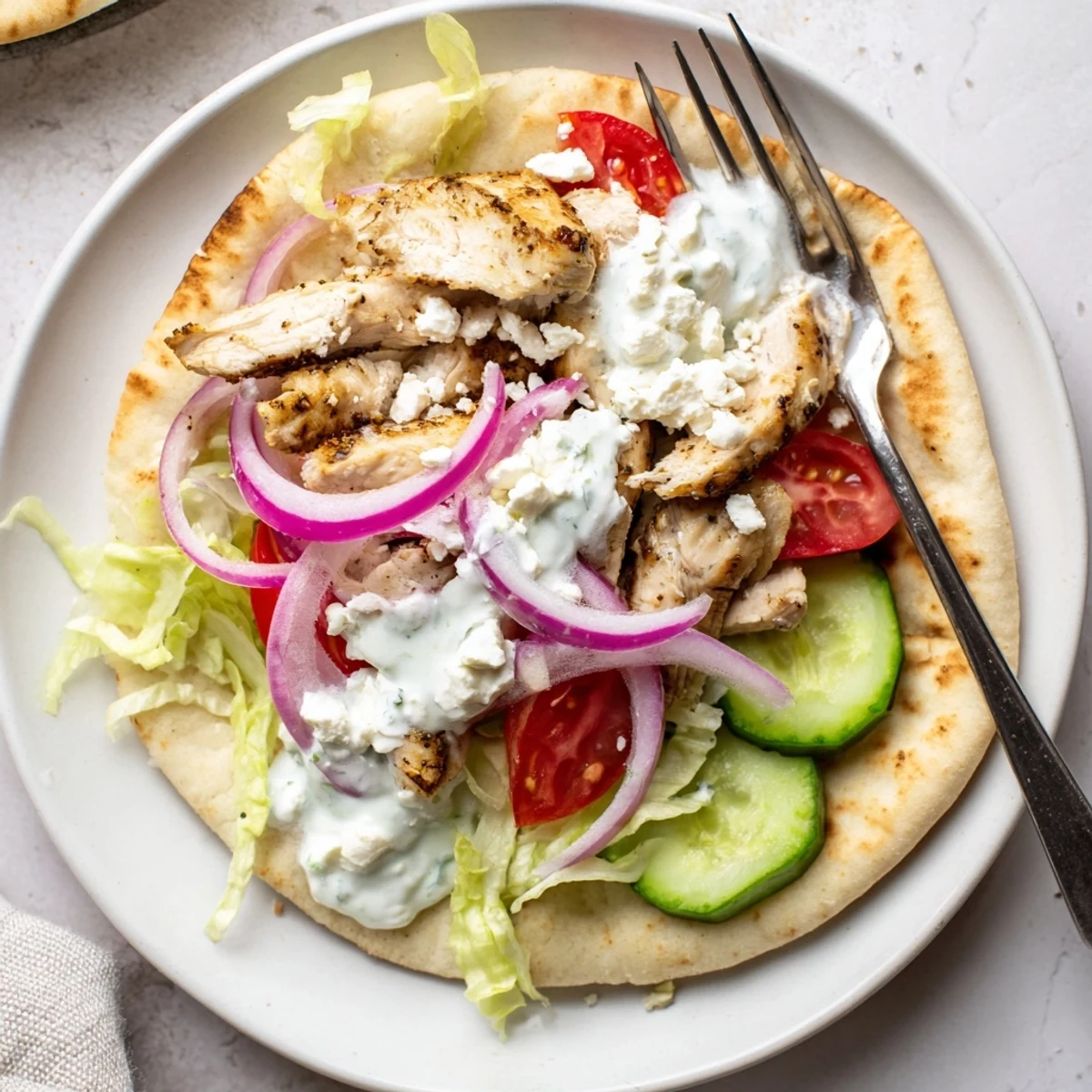 Mediterranean-style Greek grilled chicken pita wrapped in warm bread with crisp salad toppings