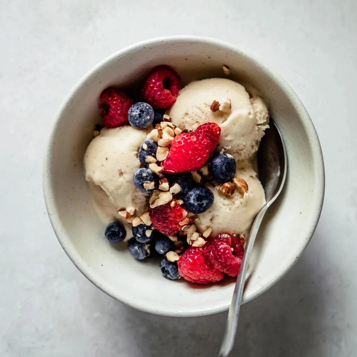 Smooth and refreshing banana nice cream swirl garnished with granola and coconut flakes