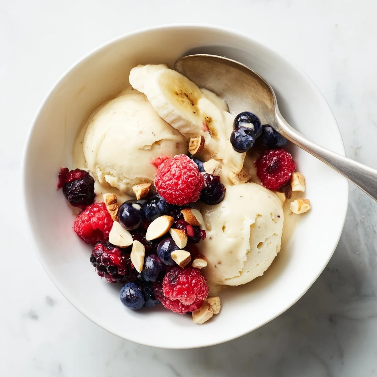 Dairy-free banana nice cream recipe scooped into serving bowls with chocolate chip garnish