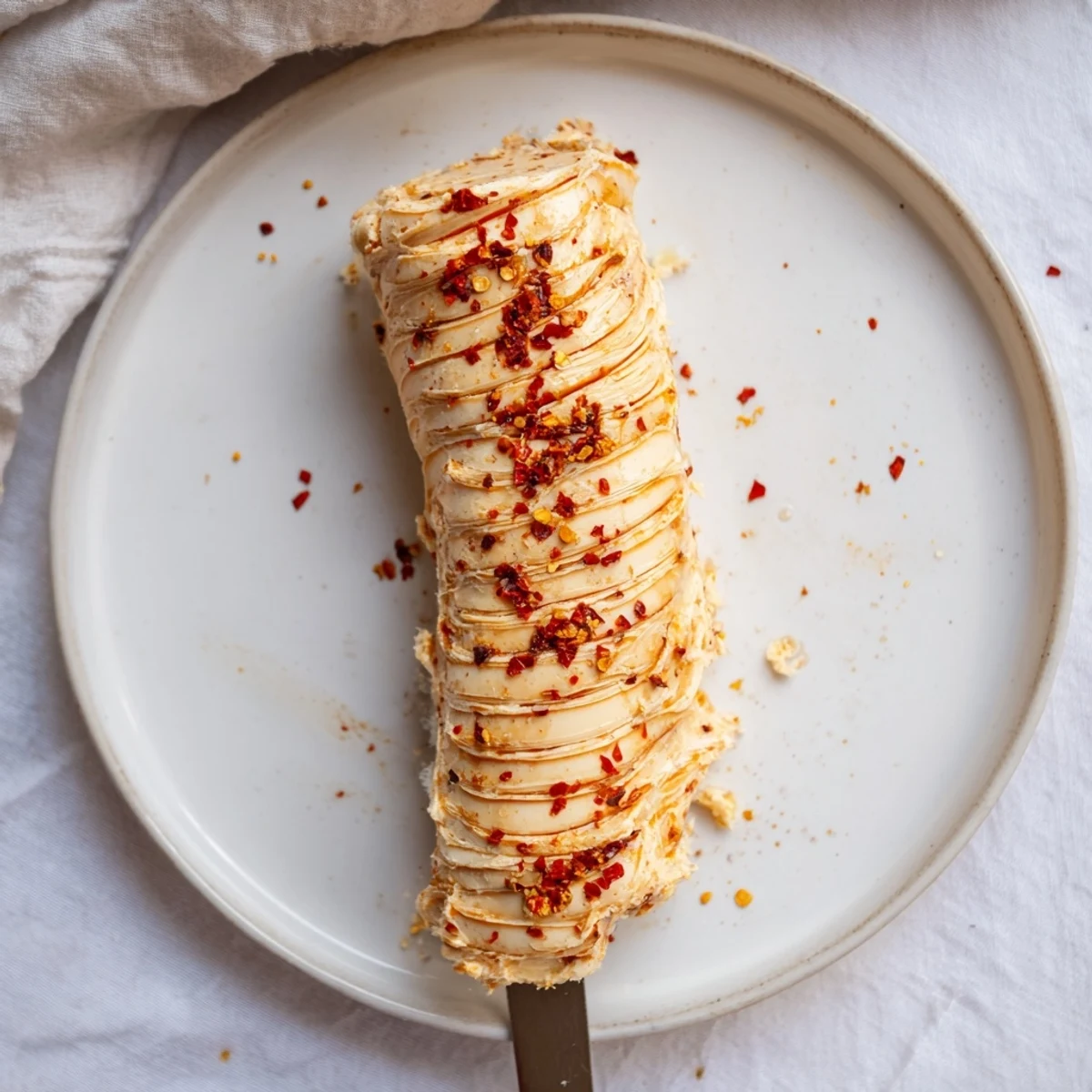 Sweet Spicy Honey Butter softened and glossy in bowl, drizzled honey glinting