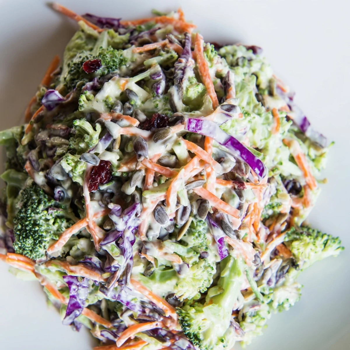 Vibrant broccoli slaw with shredded carrots and red cabbage drizzled with creamy mustard dressing
