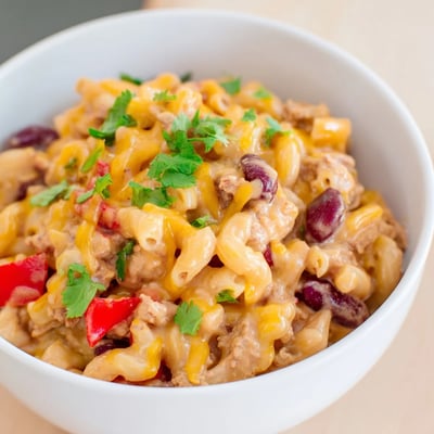 Creamy cheddar sauce melts over the Turkey Chili Mac and Cheese, ready to serve.