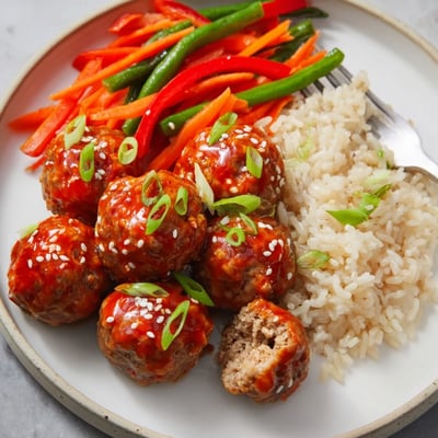 Pan-browned Hello Fresh Firecracker Meatballs tossed with honey-sriracha glaze and scallions.
